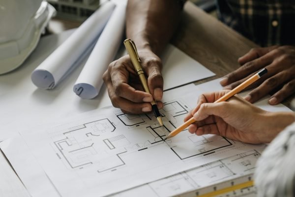 Team construction engineers working at construction site with blueprint on table